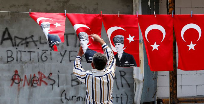 A man displays Turkey's national flags and flags printed with portraits of Mustafa Kemal Ataturk in Ankara