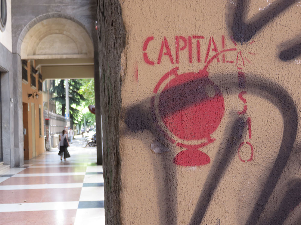 Crveni grafit na stubu u Bolonji: Capitalismo (sa globusom-bombom umesto tačke na 'i') 
