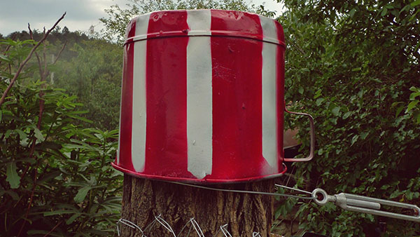 crveno-bela šerpa postavljena kao zabran na ogradu u polju