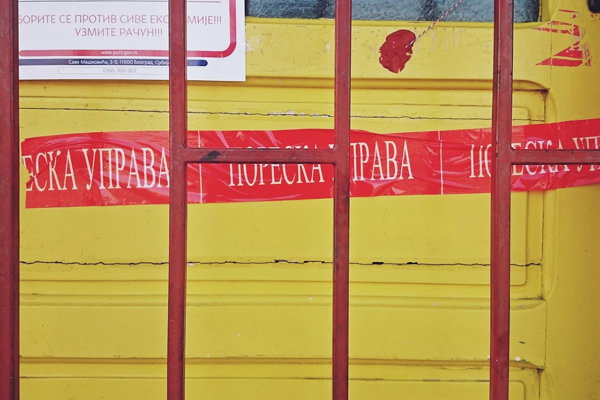 Crvena traka Poreske uprave zalepljena na vratima zatvorene radnje