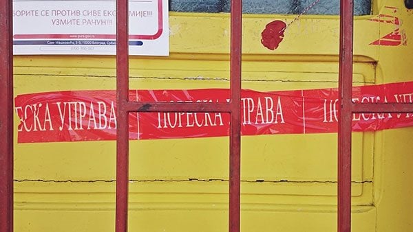 Crvena traka Poreske uprave zalepljena na vratima zatvorene radnje