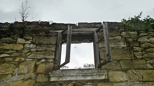 prozor na napuštenoj kamenoj kući bez krova