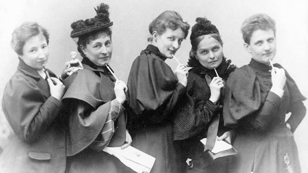 crno-bela fotografija 5 žena sa olovkama i sveskama