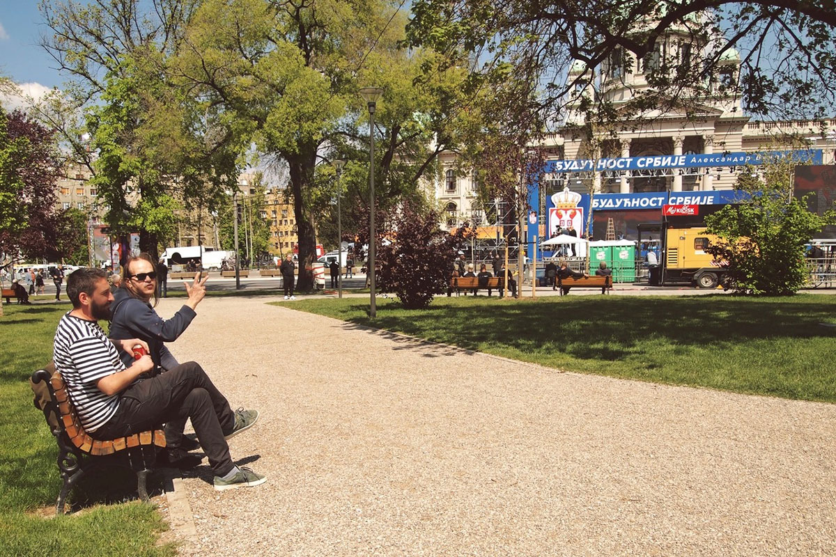 Dva čoveka sede u Pionirskom parku na klupi tokom kontramitinga vlast 19.04.2019.