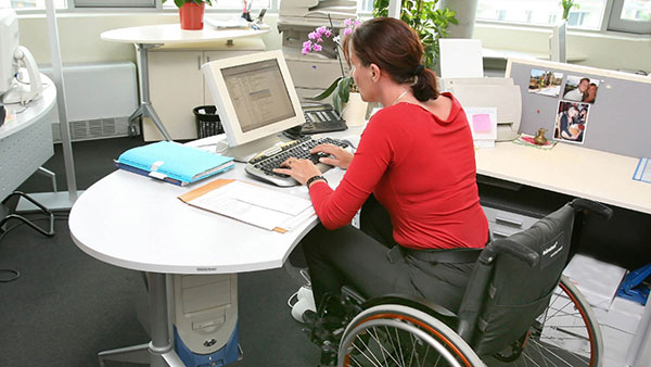 Žena u kolicima na poslu u kancelariji