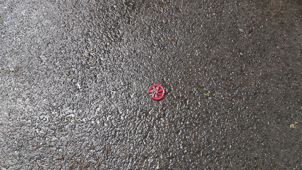 Razbijena igračka crveni točkić na asfaltu