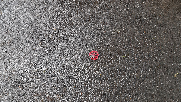 Razbijena igračka crveni točkić na asfaltu