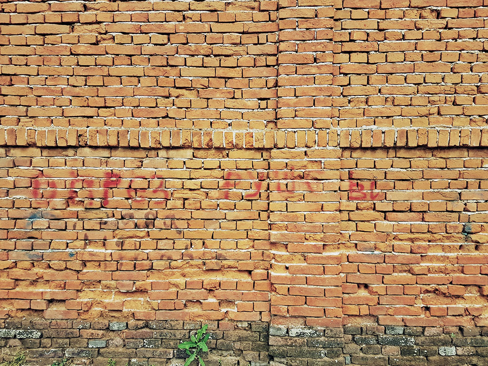 Natpis na zidu od cigala: Oprez ruše zid