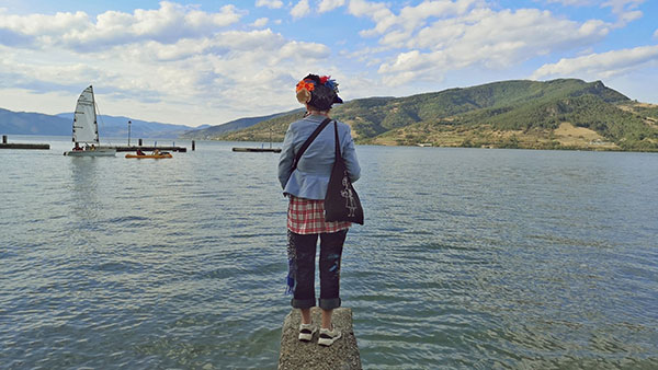 žena stoji na obali jezera