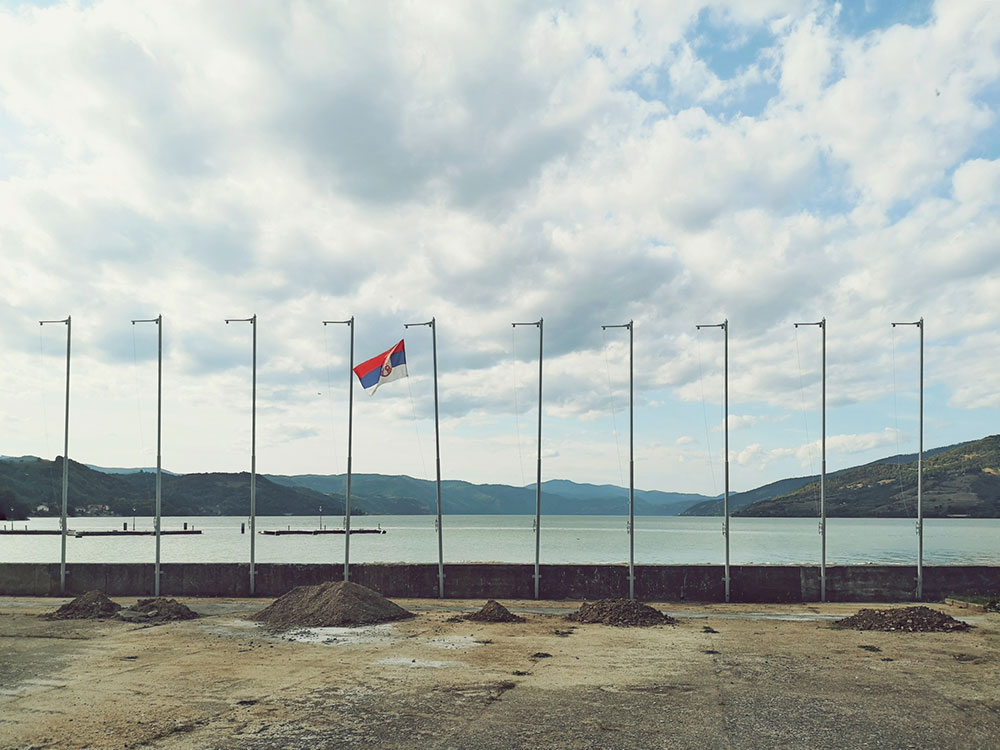 Zastava Srbije na jarbolu pored nekog jezera