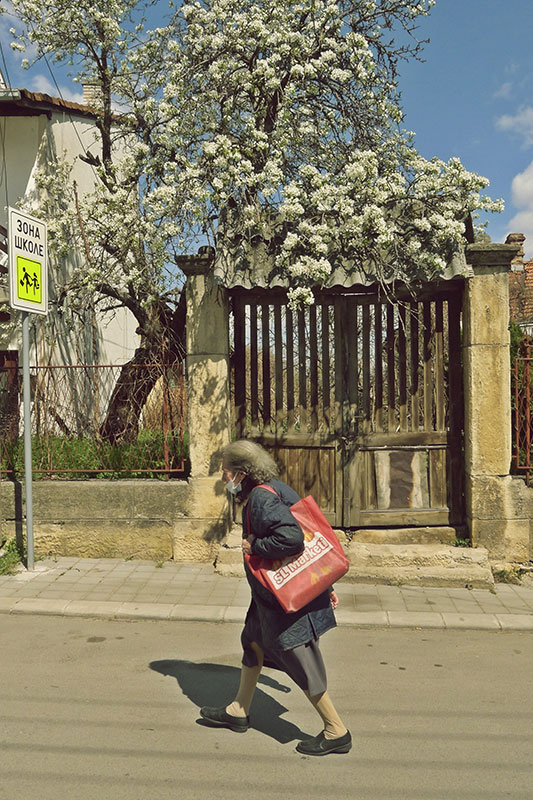 starica sa maskom na licu hoda ulicom