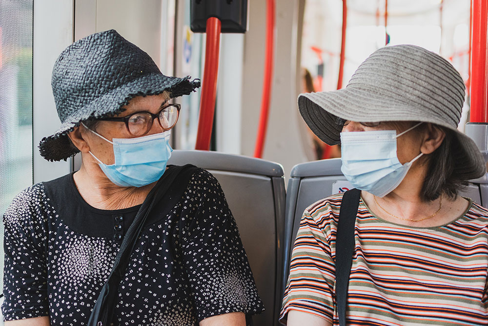 dve žene u autobusu sa maskama na licu