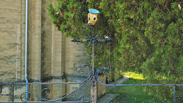 igračka - glava Paje Patka postavljena na ulaznu kapiju crkve