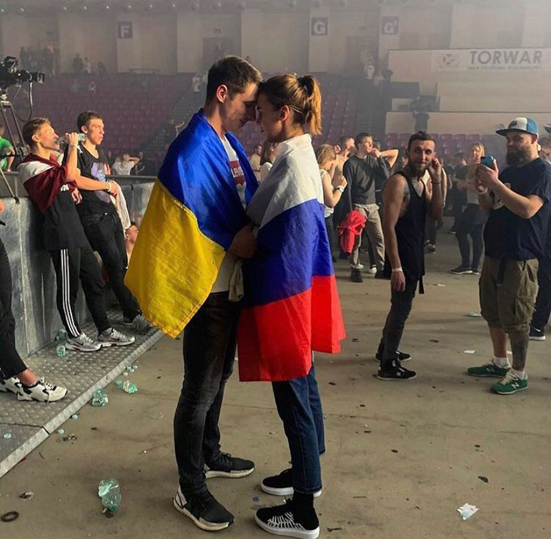 Mladić obmotan ukrajinskom i devojka obmotana ruskom zastavom